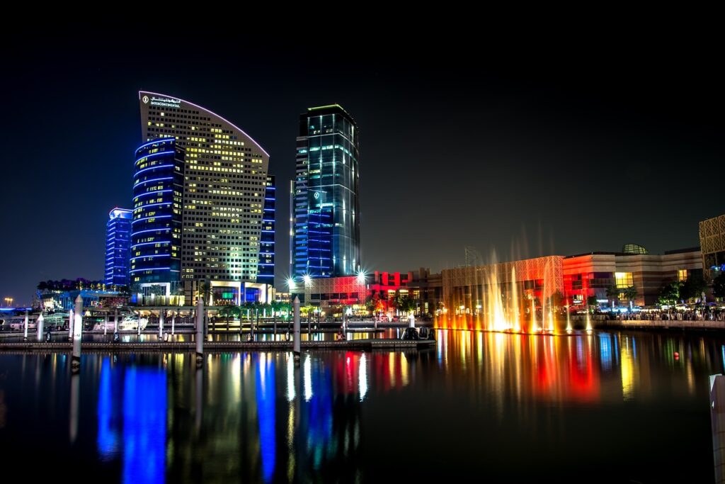 Die faszinierende Skyline von Dubai bei Nacht, die von glitzernden Wolkenkratzern und lebendigen Lichtern beleuchtet wird, und die die moderne Pracht dieser Metropole am Persischen Golf zeigt.