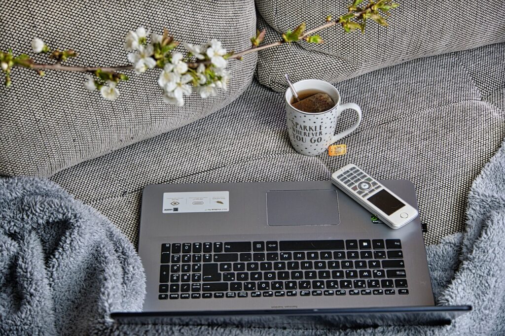 Laptop auf einer Couch platziert, symbolisiert das Arbeiten im Homeoffice.